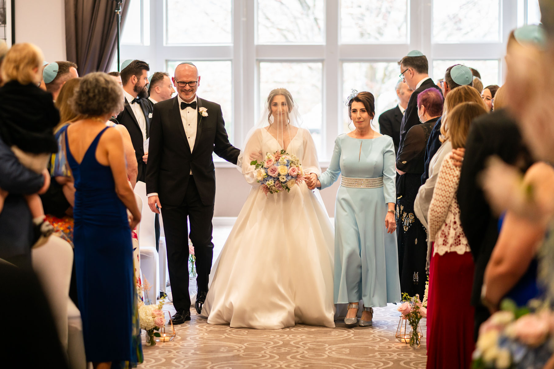 bride and parents coming down the aisle