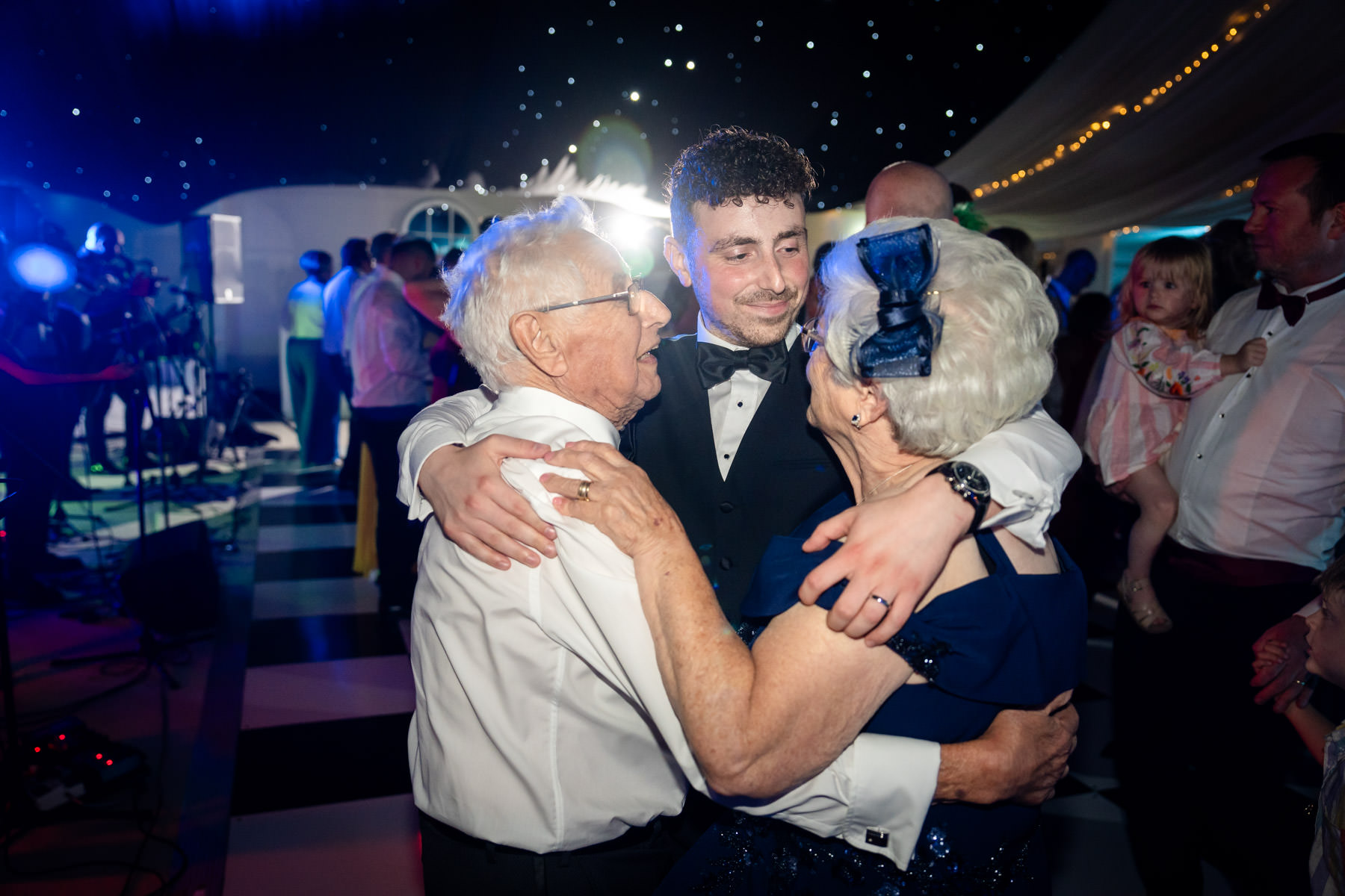 groom embraces grandparents