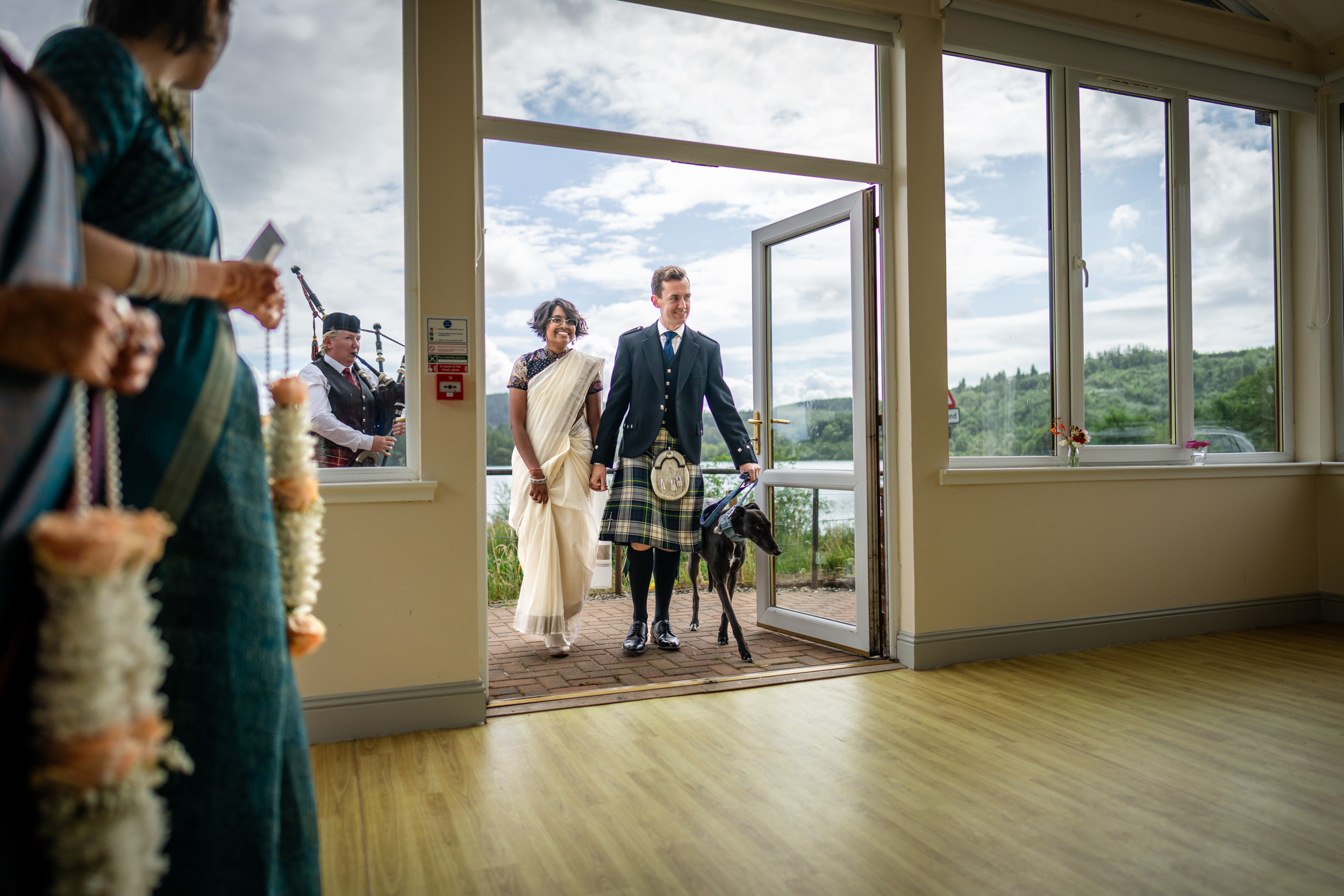 couple arrive with piper and dog Scottish Indian Kinlochard wedding